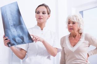 a doctor shows a patient an x-ray of the spinal column